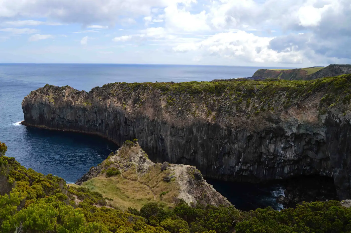 Falésia de basalto negro em colunas a entrar no Atlântico, vista do trilho das Baías da Agualva